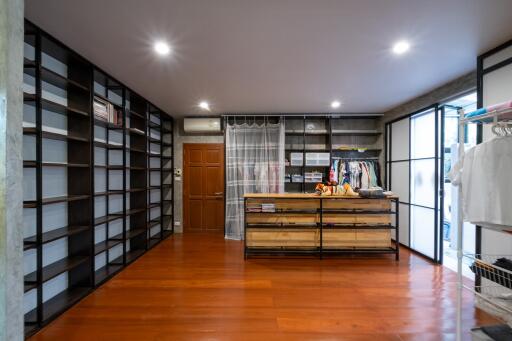 Spacious walk-in closet with wooden floors and built-in shelves