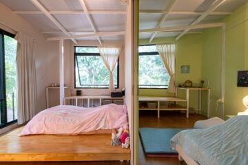 A split view of two cozy bedrooms with large windows, pastel-colored décor, and natural light