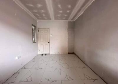 Empty bedroom with tiled floor and door