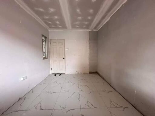 Empty bedroom with tiled floor and door