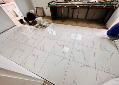 workers installing marble tiles on floor