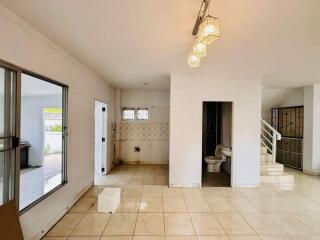 Main living area with large windows, tiled floor, modern lighting, and connected bathroom