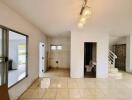 Main living area with large windows, tiled floor, modern lighting, and connected bathroom