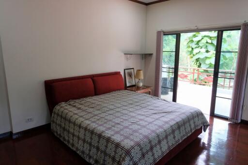 Cozy bedroom with large window and balcony view