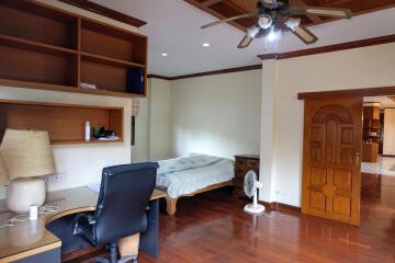 Spacious bedroom with wooden flooring and built-in furniture