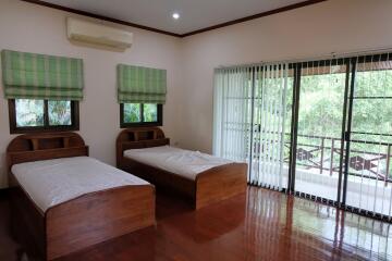 Bedroom with two single beds and large windows