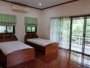 Bedroom with two single beds and large windows