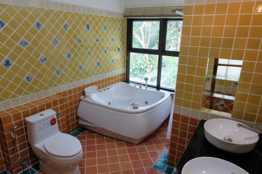 Bathroom with bathtub, toilet, and dual sinks