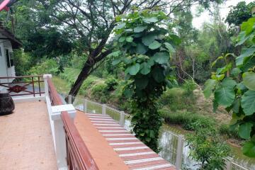 Outdoor terrace with railing and lush green view