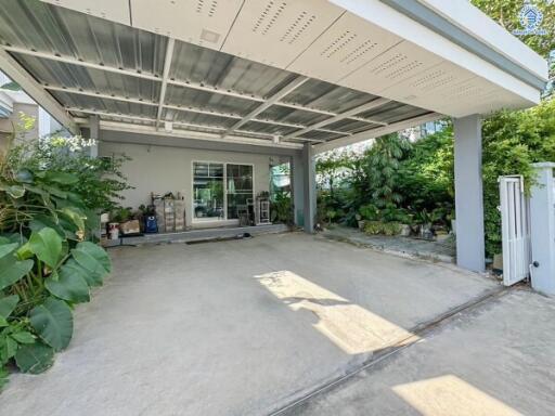 Covered carport area with surrounding greenery