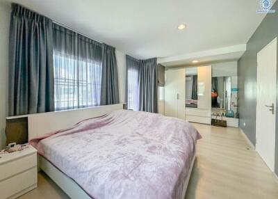 Spacious bedroom with large bed, mirrored wardrobe, and ample natural light