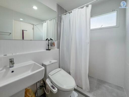 Modern bathroom with white fixtures and a shower area