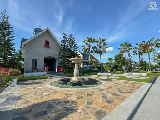 Front view of a house with a fountain in a landscaped courtyard