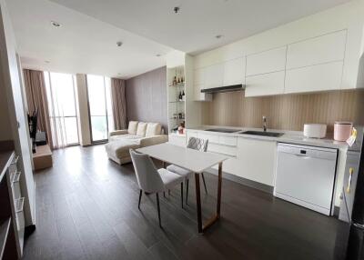 Modern open-plan kitchen and living area with dining table and large windows