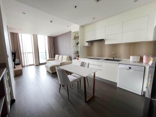 Modern open-plan kitchen and living area with dining table and large windows