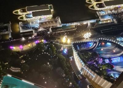 Aerial view of a city at night with illuminated waterfront and buildings