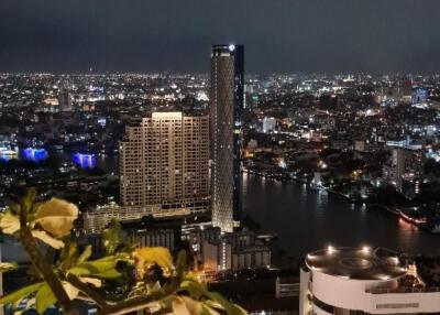 Night view of a cityscape with tall buildings and a river