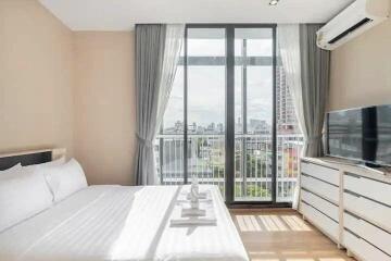 Modern bedroom with city view, bed, window, air conditioner, TV and drawers