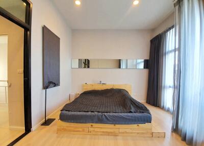 Modern bedroom with wooden bedframe and large windows