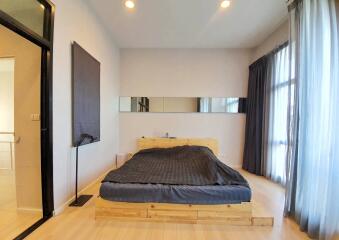 Modern bedroom with wooden bedframe and large windows