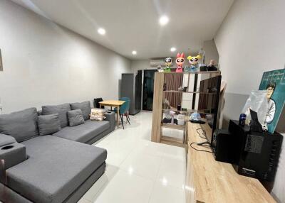 Modern living room with gray sectional sofa, dining table, and entertainment unit