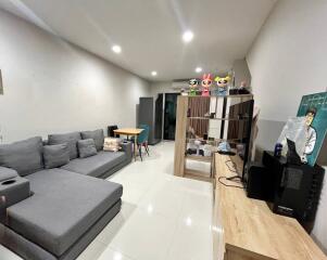 Modern living room with gray sectional sofa, dining table, and entertainment unit