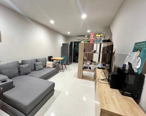 Modern living room with gray sectional sofa, dining table, and entertainment unit