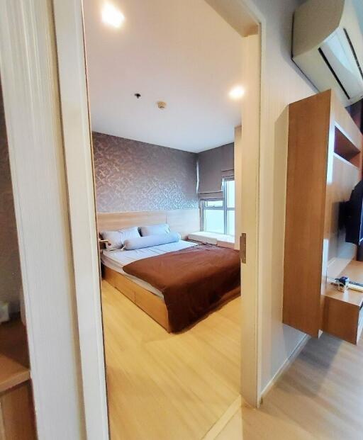 A stylish, modern bedroom with a wooden floor and built-in storage