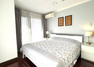 Comfortable bedroom with a large bed, bedside tables, and a lamp