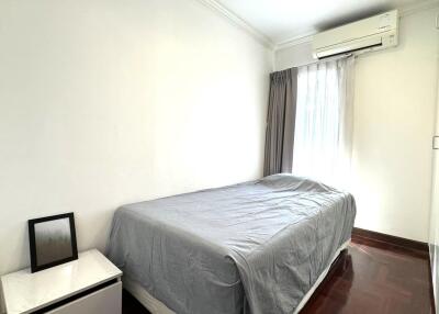 Bright bedroom with bed, nightstand, and window.