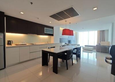 Modern kitchen with dining area and living room in the background