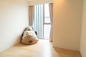 Empty bedroom with large window and bean bag chairs