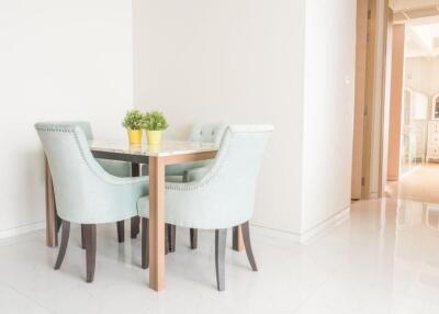 Small dining area with light blue chairs and a table with green plants