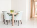 Small dining area with light blue chairs and a table with green plants