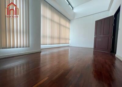 Spacious living area with hardwood floors and large windows