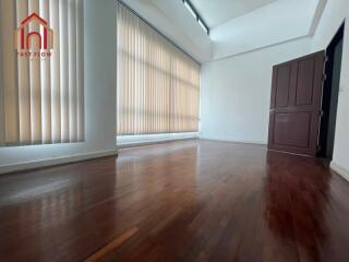 Spacious living area with hardwood floors and large windows