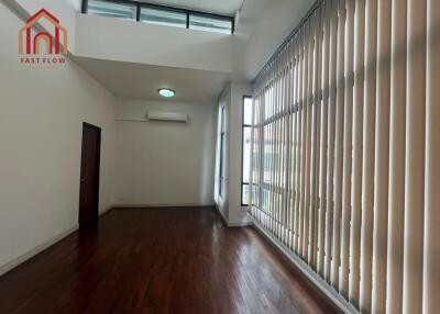 Spacious living room with high ceiling and large windows