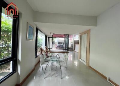 Spacious living room with large windows and glass dining table