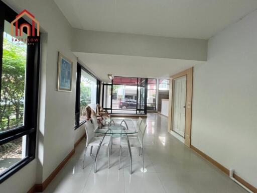 Spacious living room with large windows and glass dining table