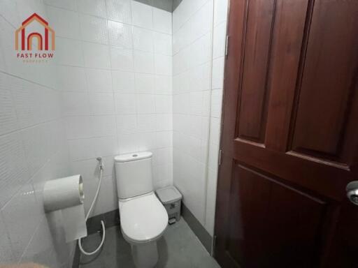 Small bathroom with toilet and wooden door