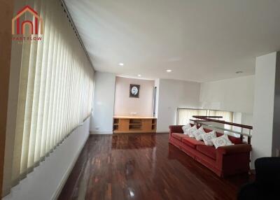 Spacious living room with wooden flooring and a red couch