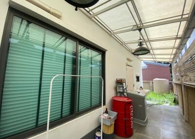 Covered outdoor laundry area with storage and appliances