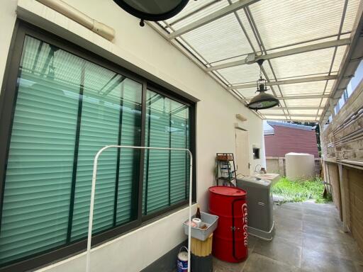 Covered outdoor laundry area with storage and appliances