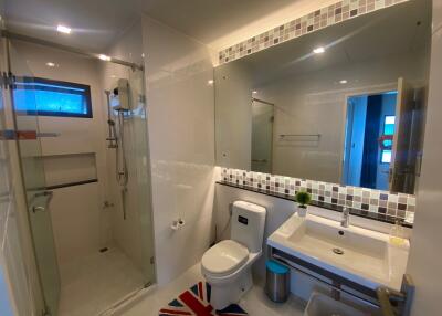 Modern bathroom with glass shower, large mirror, and basin