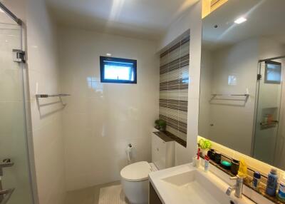 Modern bathroom with sink, mirror, toilet, and shower