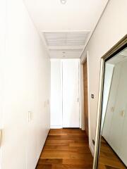 Hallway with wooden flooring and a large mirror