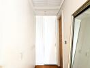 Hallway with wooden flooring and a large mirror