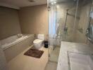 Spacious modern bathroom with glass shower, bathtub, and marble countertop sink.