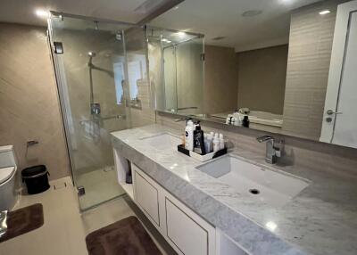 Modern bathroom with glass shower, large vanity, and neutral tones
