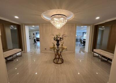 Spacious entrance hallway with chandelier and decorative table